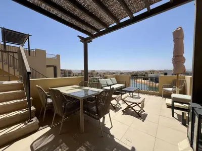 a patio with a table and chairs on a roof at Tawila Luxury 2BR Skyline Loft • Rooftop in Hurghada