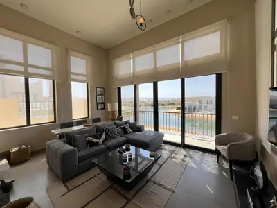 a living room with a couch and a table and windows at Tawila Luxury 2BR Skyline Loft • Rooftop in Hurghada