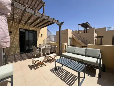 a patio with a couch and a table and chairs at Tawila Luxury 2BR Skyline Loft • Rooftop in Hurghada