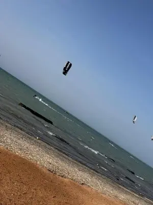 a kite flying over the ocean on a beach at live in luxury hotel-style apartment in the heart of the city in Hurghada