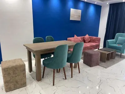 a dining room with a table and chairs and a couch at live in luxury hotel-style apartment in the heart of the city in Hurghada