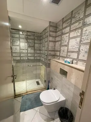 a bathroom with a glass shower and a toilet at Apartment in El gouna mangrouovy in Hurghada