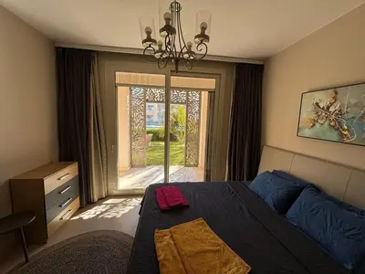 a bedroom with a bed and a large window at Apartment in front of the beach in Hurghada