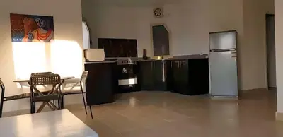 a kitchen with a refrigerator and a table and chairs at Regency towers résidence in Hurghada