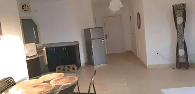 a kitchen with a table and a refrigerator at Regency towers résidence in Hurghada