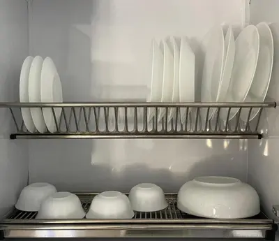 a shelf with white plates and bowls in a kitchen at Bayt Hassan S18 - Fabulous Roof top 1 bedroom apartment in Hurghada