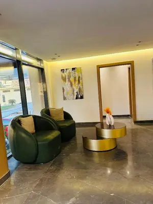 a living room with two green chairs and a table at Unique Studio Free access beach in Hurghada
