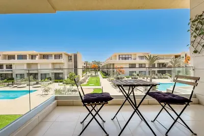 a balcony with a table and chairs and a pool at The Softline Studio G-Cribs in Hurghada