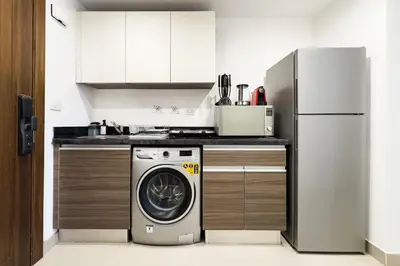 a kitchen with a washing machine and a refrigerator at The Softline Studio G-Cribs in Hurghada