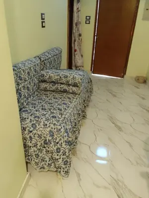 a living room with a blue and white patterned chair at Neu Student Home in Jazīrat Aswān