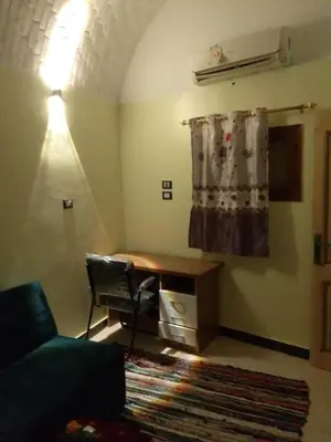 a living room with a desk and a chair at Neu Student Home in Jazīrat Aswān