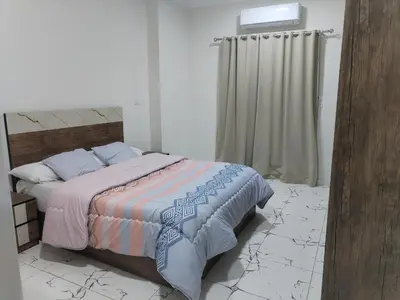 a bedroom with a bed in a room with marble floors at Dream House in Hurghada