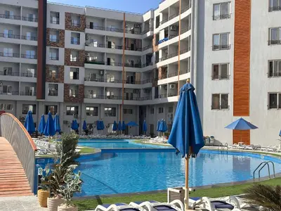 a swimming pool in front of a large apartment building at Apartment with private beach 09D in Hurghada