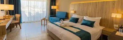 a hotel room with a large bed and a blue chair at Salvatore Rooms All Inclusive -Cornich Street in Hurghada