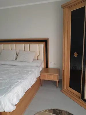 a bedroom with a large bed and a table at شالية في كمباوند سكانديك عرابيا in Hurghada