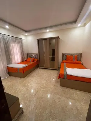 a bedroom with two beds with orange sheets at Mirage Bay Village in Hurghada