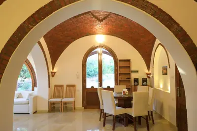 a living room with an archway and a table and chairs at Desert Rose apartments in Luxor
