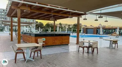 a patio with tables and chairs and a bar at شالية منتجع سكانديك عرابيا in Hurghada