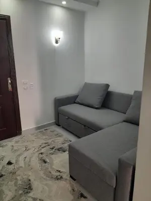 a living room with a couch and a bed at شالية منتجع سكانديك عرابيا in Hurghada