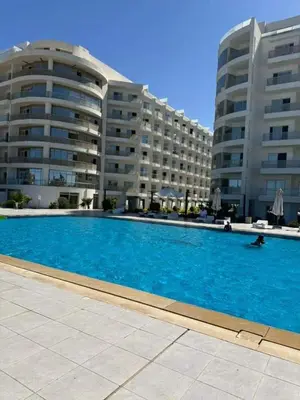 a large swimming pool in front of two large buildings at شالية منتجع سكانديك عرابيا in Hurghada