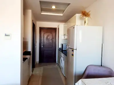 a kitchen with a white refrigerator and a door at Units for rent in Hurghada in Hurghada
