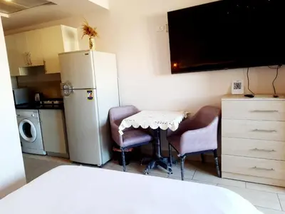 a kitchen with a table and two chairs and a refrigerator at Units for rent in Hurghada in Hurghada