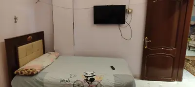a bedroom with a bed and a tv on the wall at Souzan house in Luxor