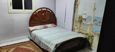a bed in a room with a picture of the ocean at Souzan house in Luxor