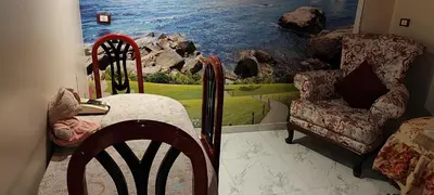 a room with a painting of the ocean and a chair at Souzan house in Luxor