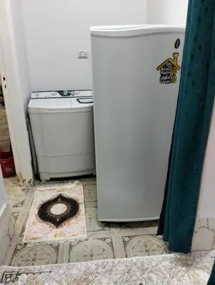 a small refrigerator in a kitchen with a tile floor at apartment in Hurghada