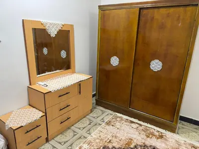 a bathroom with a wooden cabinet and a mirror at apartment in Hurghada