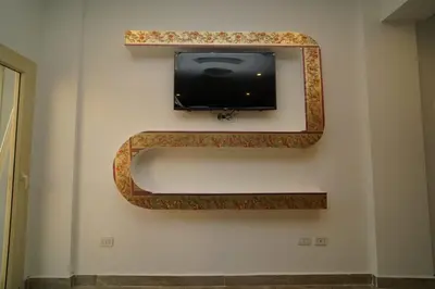a flat screen tv on a wall with a mirror at Mirage Aqua Park Villa in Hurghada