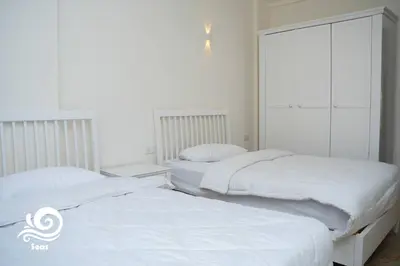 two beds in a bedroom with white walls at Mirage Aqua Park Villa in Hurghada
