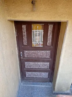 a brown door with a window on a building at Nasser in Jazīrat Aswān