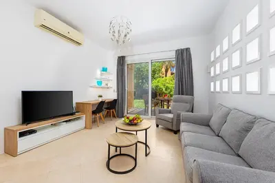 a living room with a couch and a tv at Townhouse South Marina in Hurghada