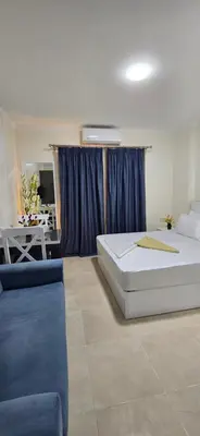 a bedroom with a bed and a blue couch at Tiba Golden Red Sea Coral Hurghada in Hurghada