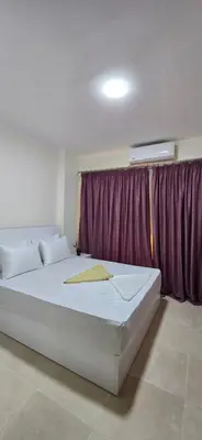 a large white bed in a room with a purple curtain at Tiba Golden Sun-kissed Hurghada in Hurghada