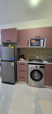 a kitchen with a refrigerator and a stove and a microwave at Tiba Golden Sun-kissed Hurghada in Hurghada