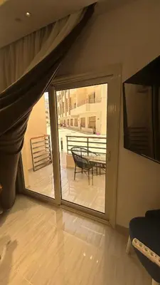 a room with a sliding glass door with a table on a balcony at Flat In Elhambra in Hurghada
