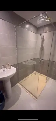 a bathroom with a glass shower and a sink at Flat In Elhambra in Hurghada