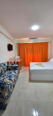 a bedroom with two beds and an orange curtain at Tiba Golden White Lagoon Hurghada in Hurghada