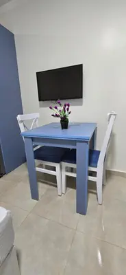 a blue table with two chairs and a vase with flowers at Tiba Golden Royal Blue Hurghada in Hurghada