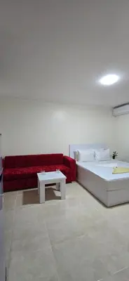 a living room with a bed and a red couch at Tiba Golden Lagoon Hurghada in Hurghada