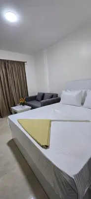 a large white bed in a room with a couch at Tiba Golden Private Beach Hurghada in Hurghada