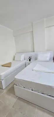 two beds in a room with white walls at Tiba Golden Sand Dune Hurghada in Hurghada