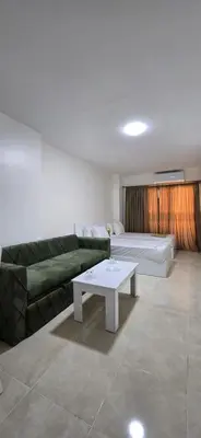 a living room with a green couch and a coffee table at Tiba Golden Crystal Water Hurghada in Hurghada