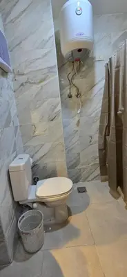 a bathroom with a toilet and a light on the wall at Tiba Golden Crystal Water Hurghada in Hurghada