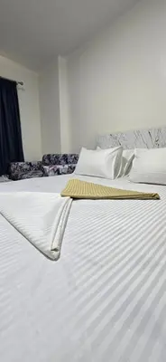 a large white bed with a yellow blanket on it at Tiba Golden Blue Coral Hurghada in Hurghada