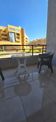 a white table and a chair on a balcony at Tiba Golden Crystal Oasis Hurghada in Hurghada