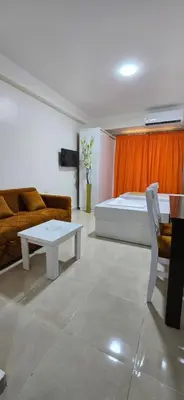 a bedroom with a bed and a couch and a table at Tiba Golden Golden Coast Hurghada in Hurghada